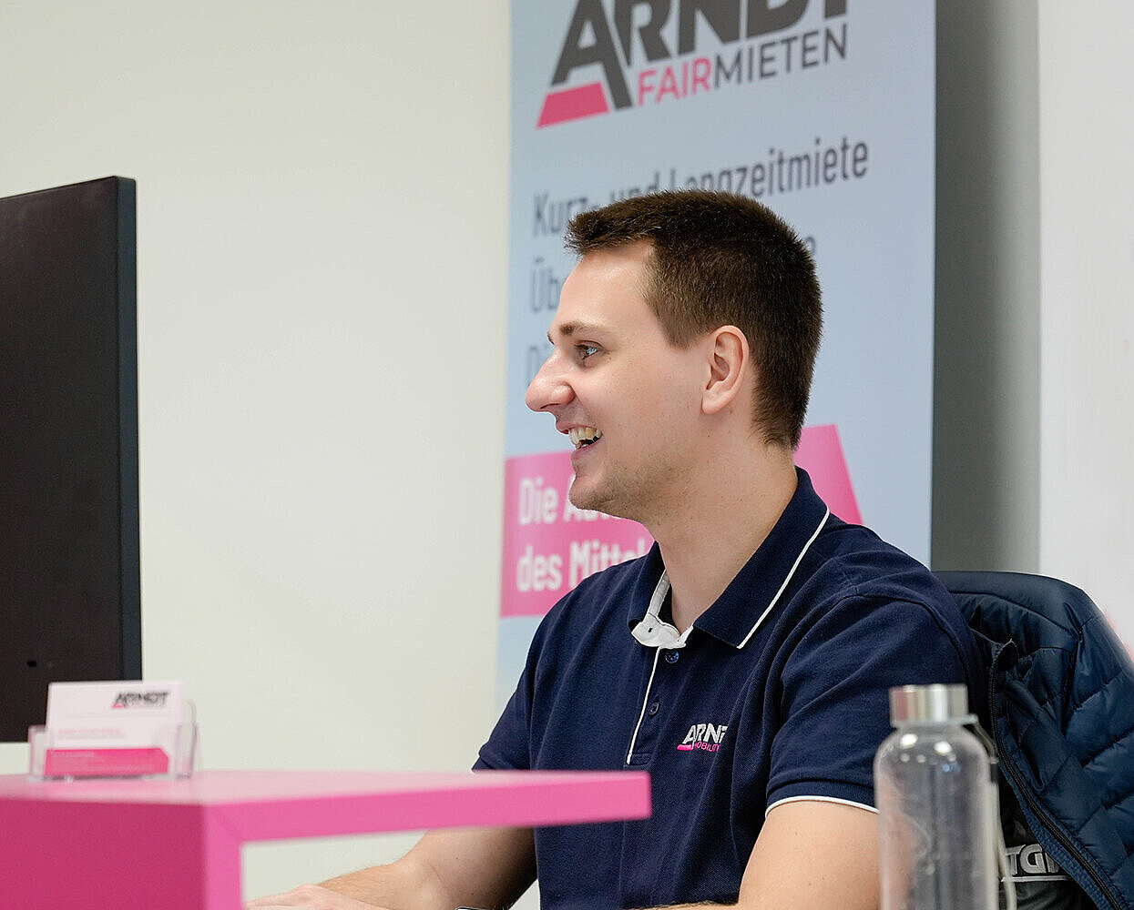 Mann sitzt am Computer in der Niederlassung der Autovermietung Arndt