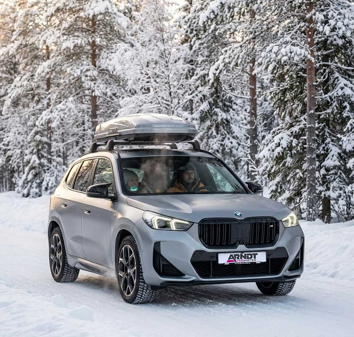 BMW X1 SUV mit Dachbox und Familie auf Winterreise – Familien-SUV mieten bei Arndt