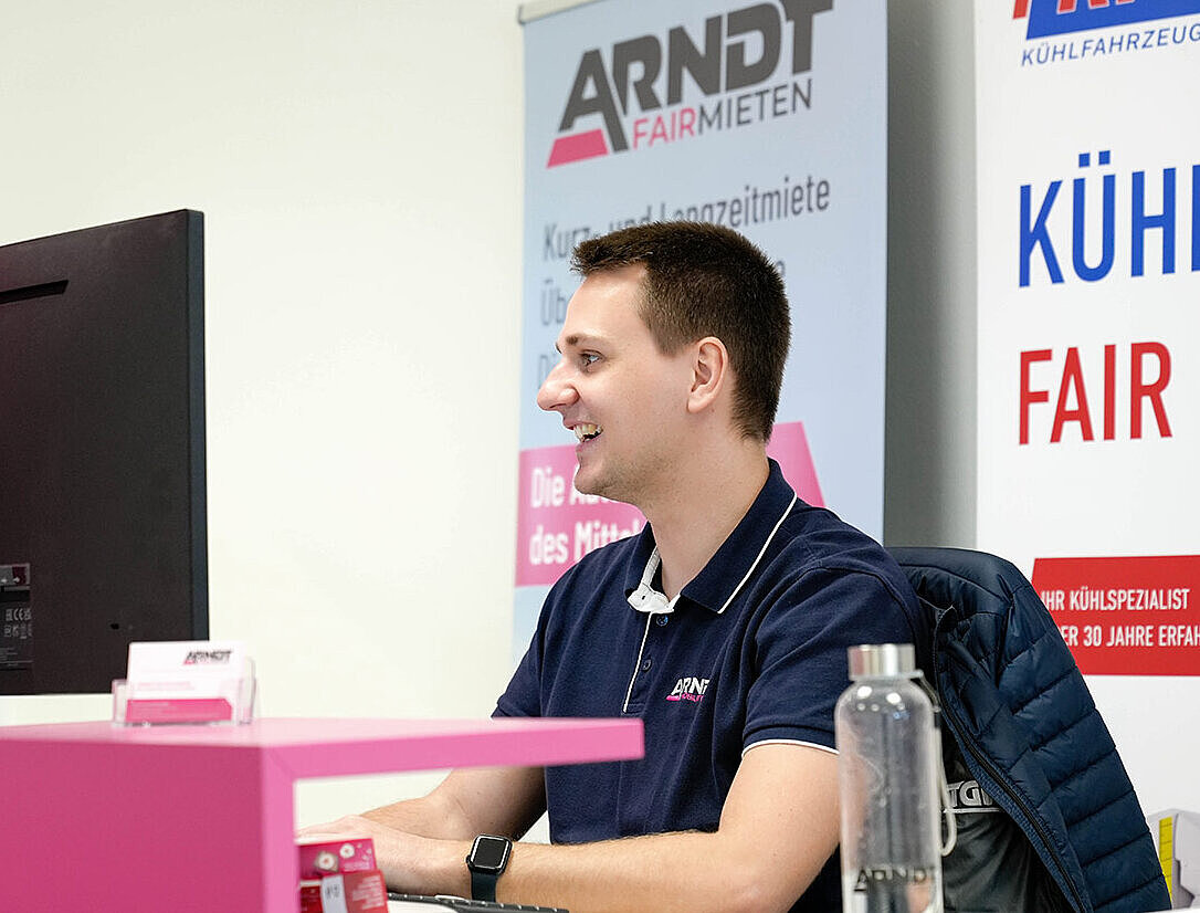 freundlicher Mitarbeiter der Station Autovermietung Arndt Stuttgart am Computer sitzend 
