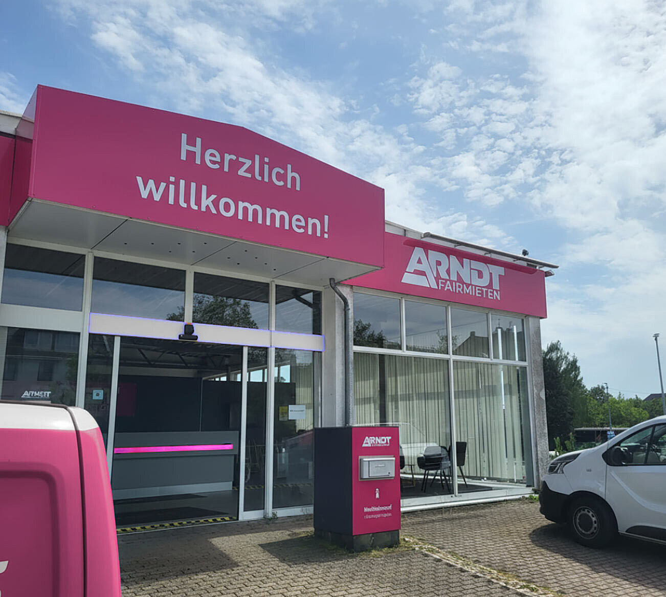 Eingang der Autovermietung Arndt in Aachen mit Arndt-Transporter vor der Station – Mietwagen und Transporter mieten