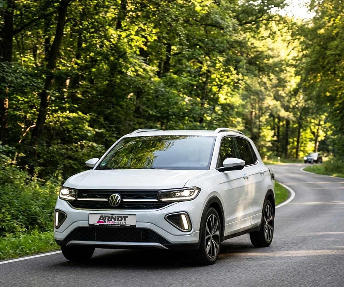 Volkswagen T-Cross SUV auf kurviger Waldstraße – VW T-Cross mieten bei Arndt