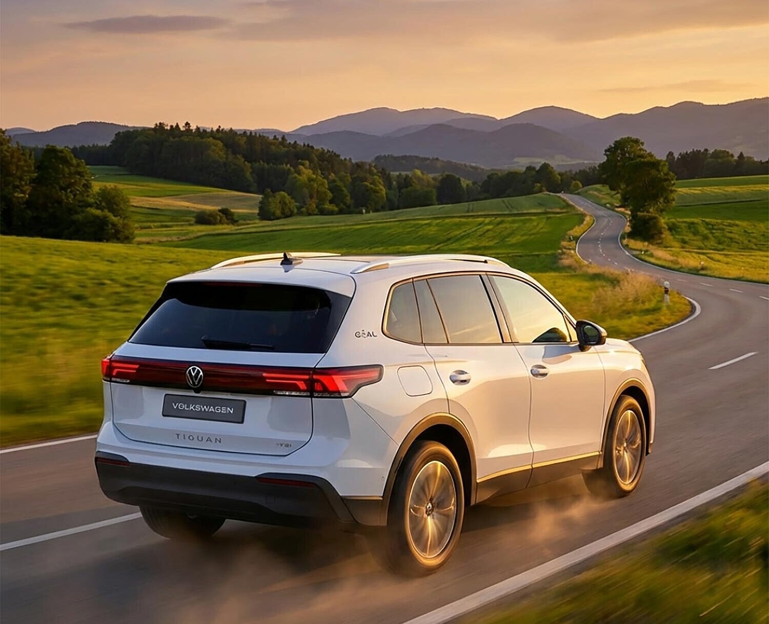 Volkswagen Tiguan SUV fährt bei Sonnenuntergang durch die Landschaft – VW Tiguan mieten bei Arndt