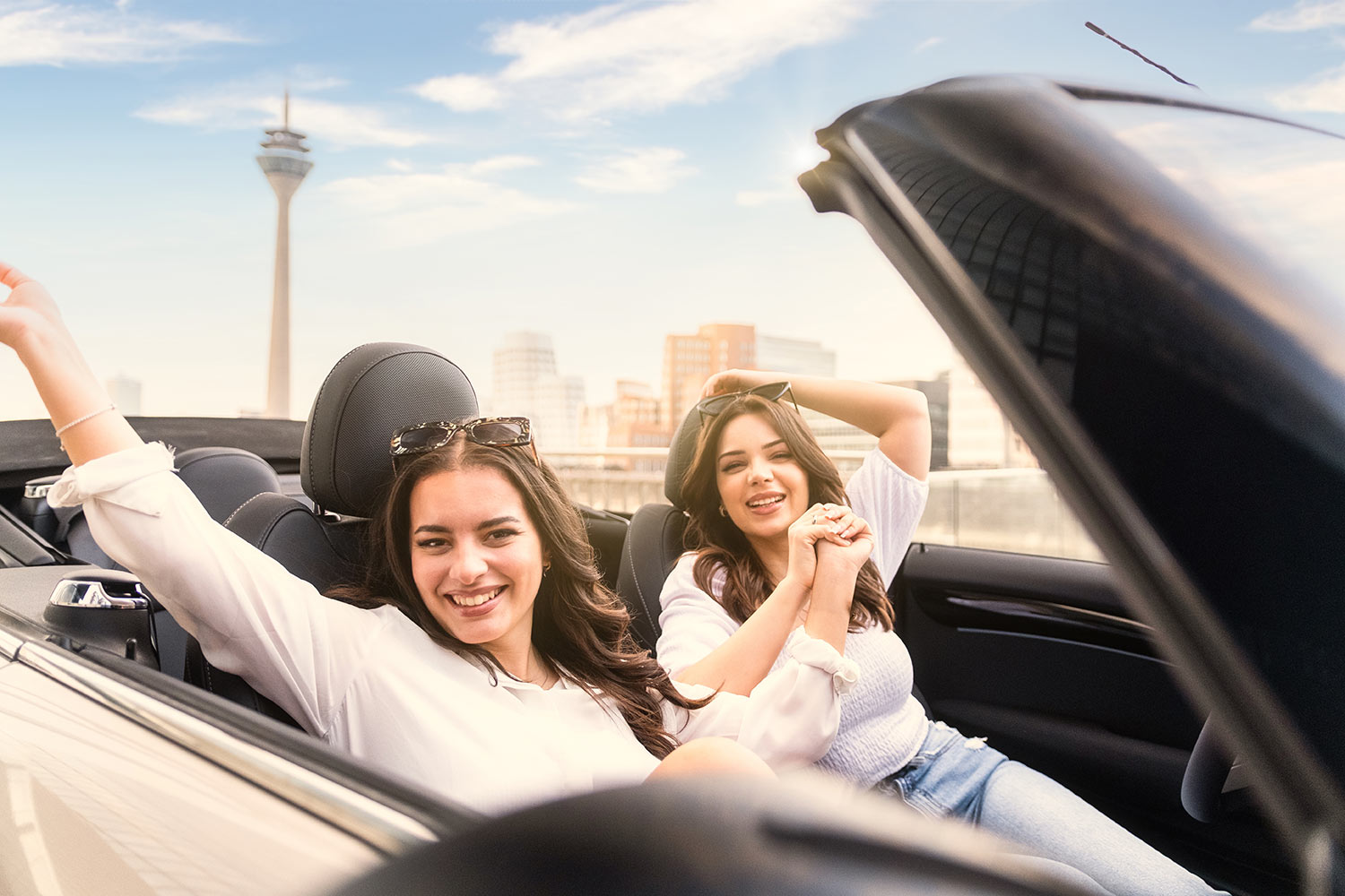 Zwei Frauen lächeln in die Kamera in einem Mini Cooper S Cabrio